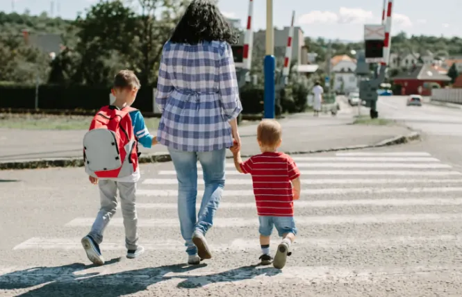 Ouder steekt te voet over met de kinderen